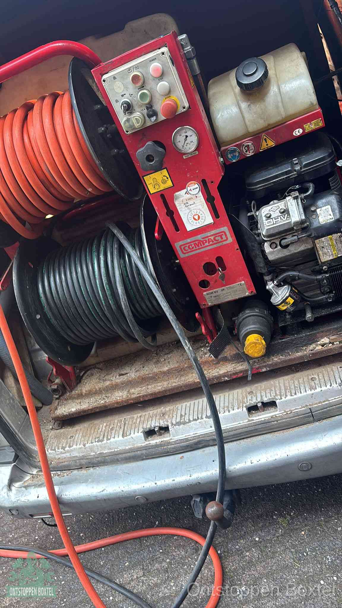 Een rood hogedruk-rioolreinigingstoestel in de laadbak van de bedrijfsbus, apparatuur voor een hardnekkige afvoerverstopping in Boxtel