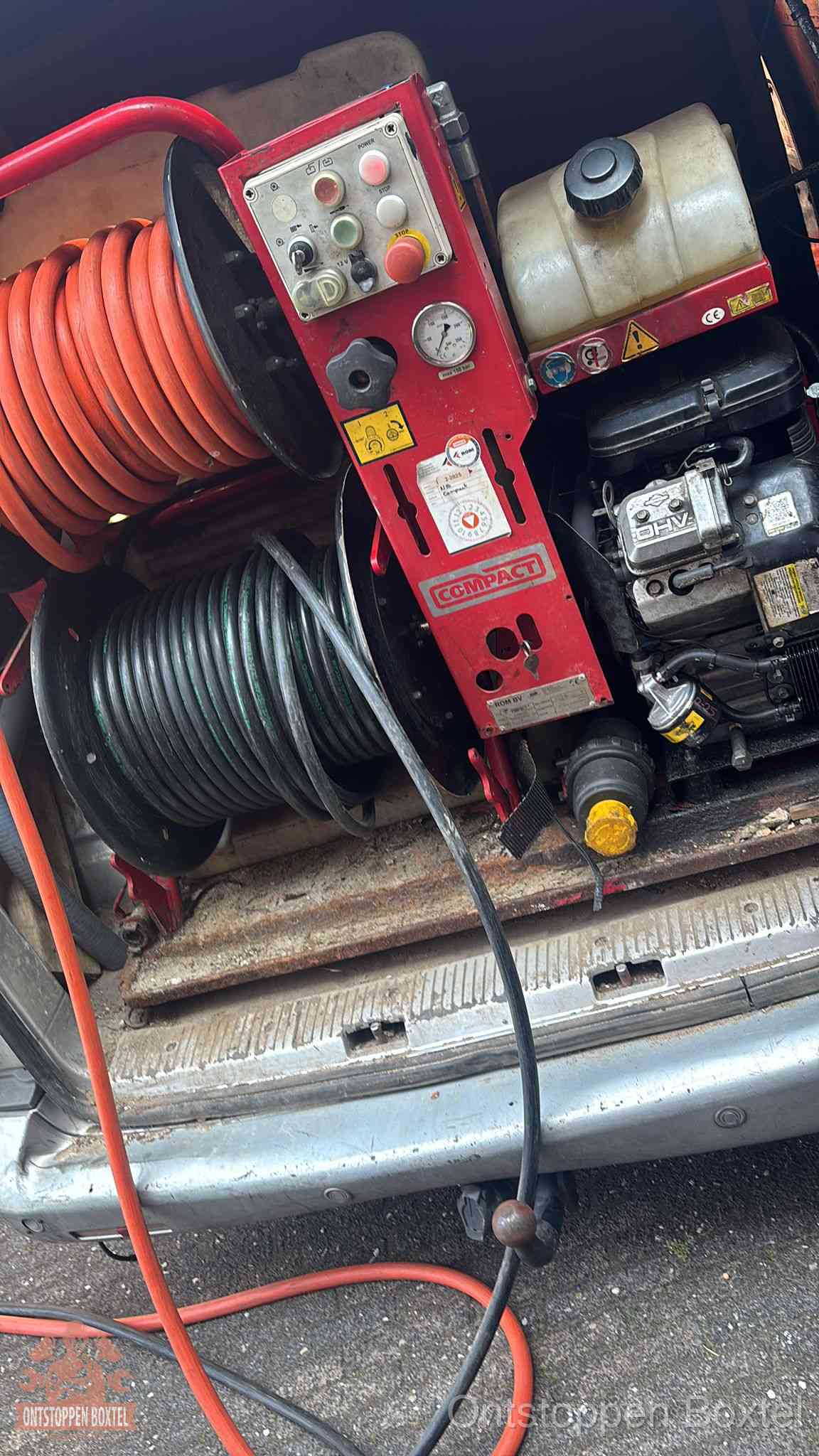 Een rood hogedruk-rioolreinigingstoestel met slangen in de laadbak van de bedrijfsbus, apparatuur voor een hardnekkige wc-verstopping in Boxtel