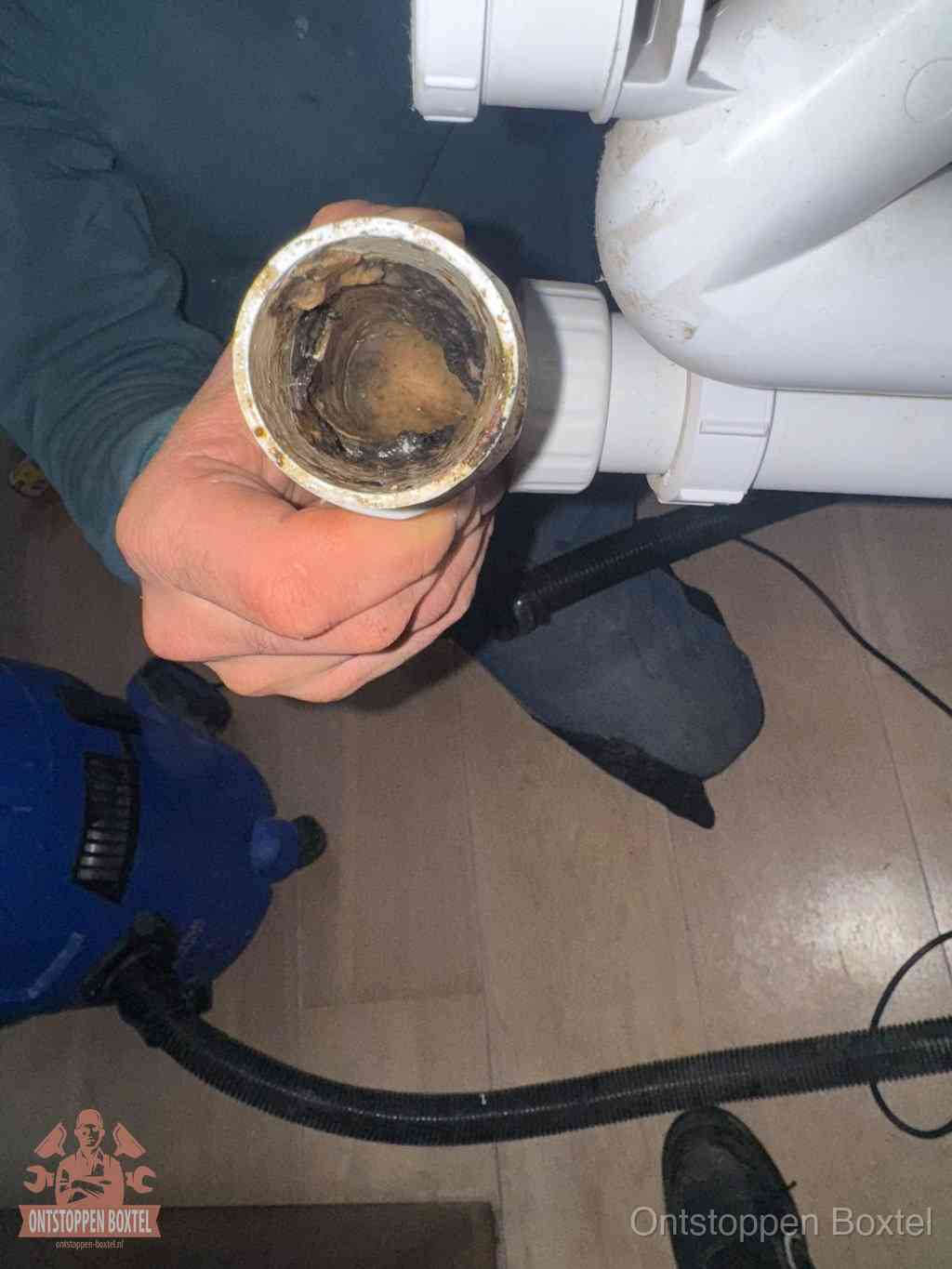Een losgekoppelde afvoerbuis die van binnen volledig is dichtgeslibd met vet en aanslag, de meest voorkomende oorzaak van een verstopte gootsteen in Boxtel