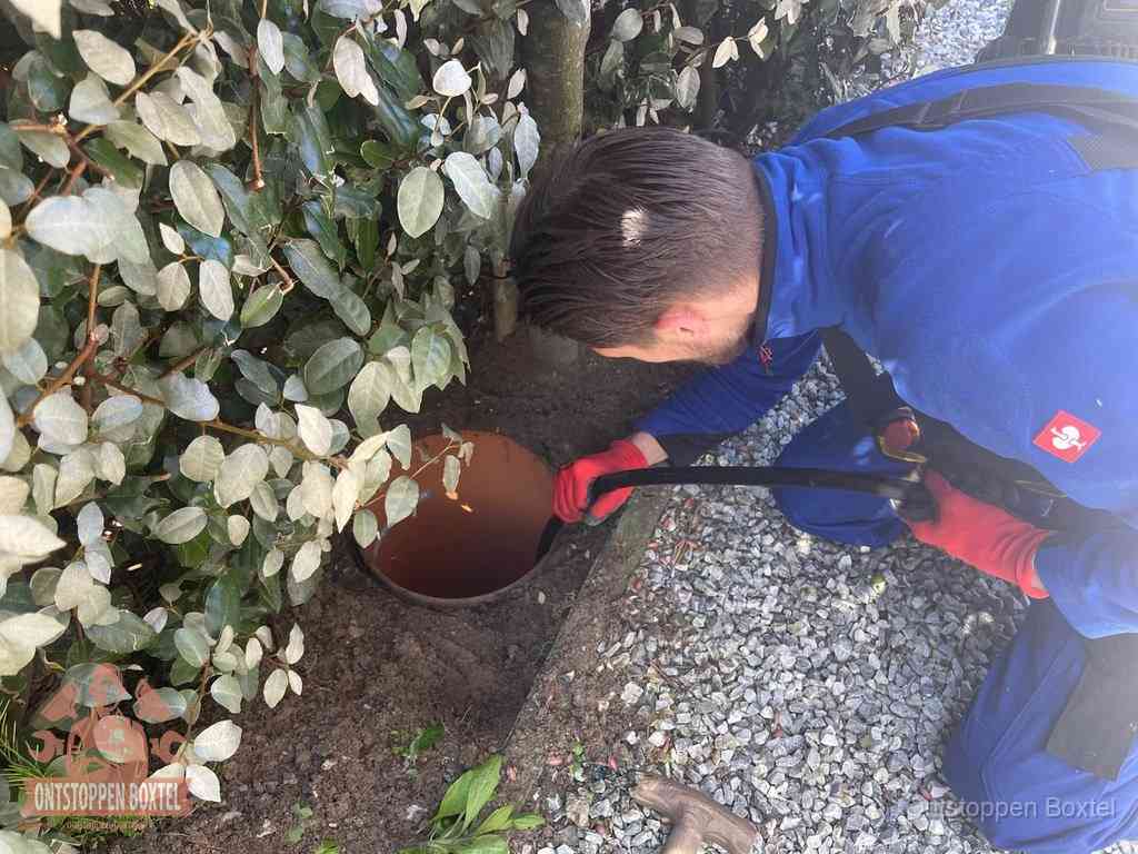 Monteur reinigt een rioolput met een slang, periodieke rioolreiniging in Boxtel