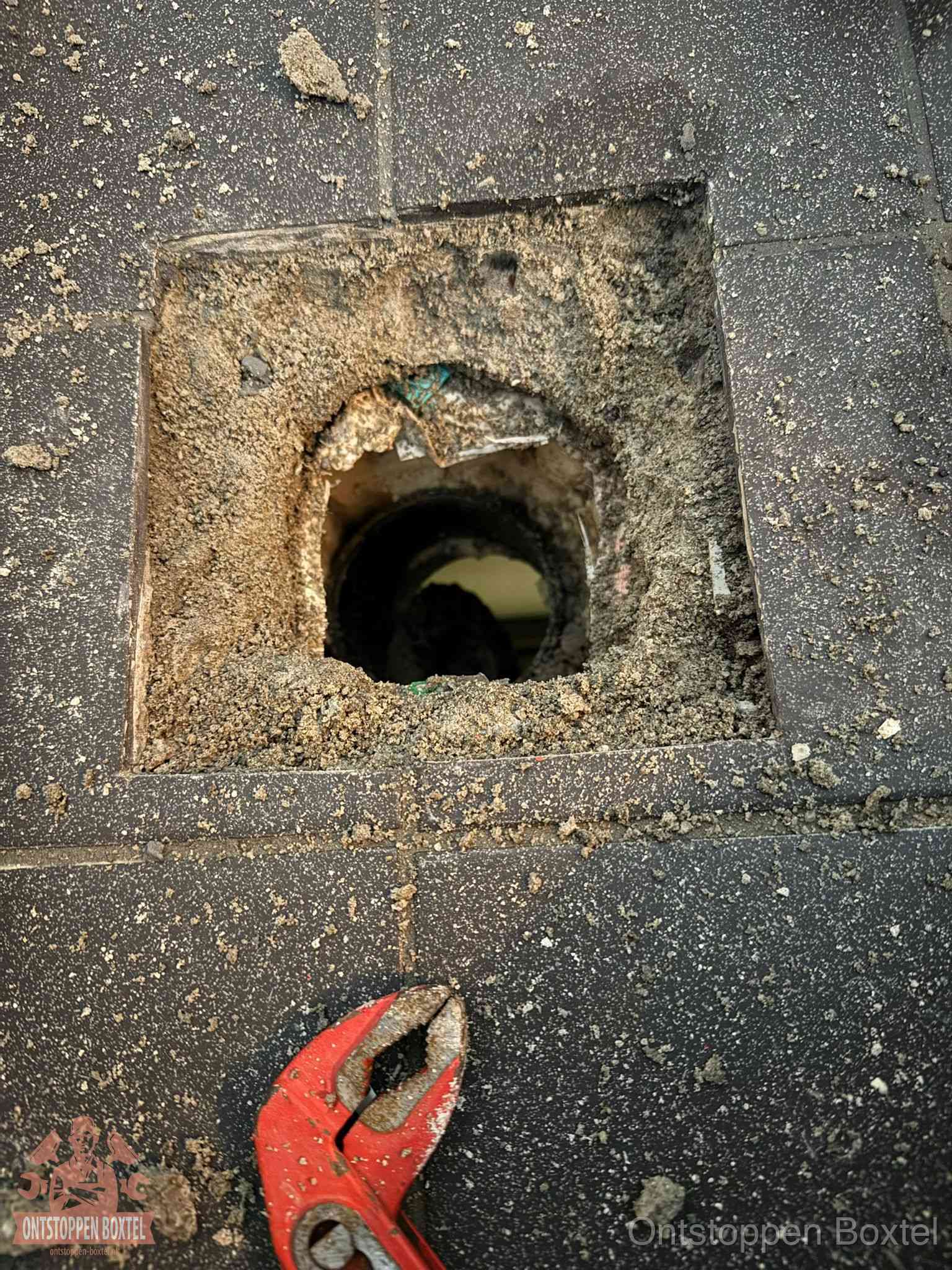 Geopend rioolputje op de erfgrens dat laat zien wie eigenaar is van de riolering in Boxtel
