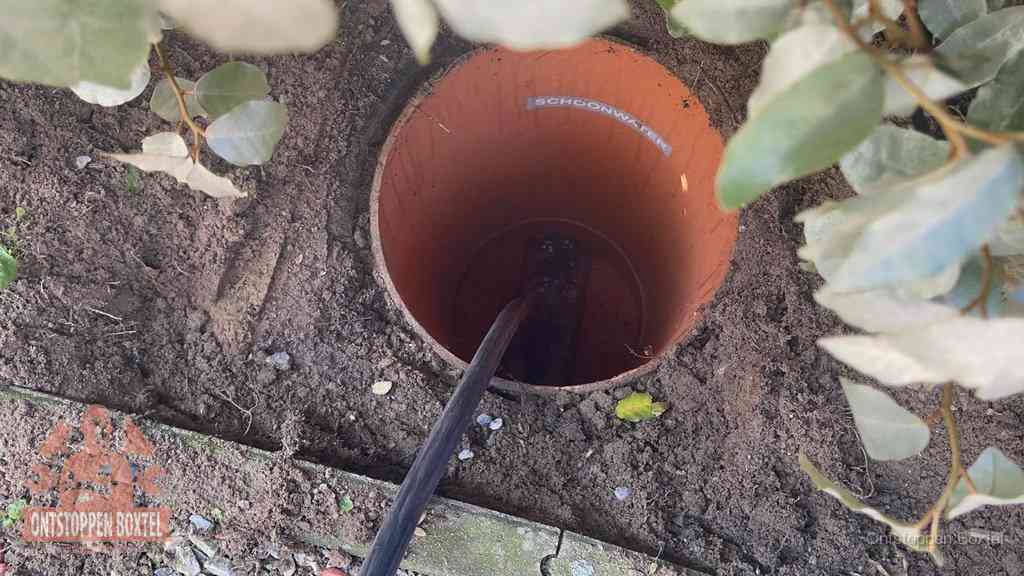 Open inspectieput in de tuin waar een veer rioolvliegjes en stankoverlast aanpakt in Boxtel