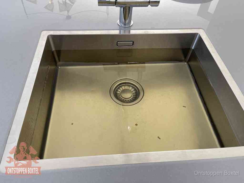 Stilstaand water in een rvs spoelbak dat niet wegloopt, een duidelijk signaal van een gootsteenverstopping in Boxtel