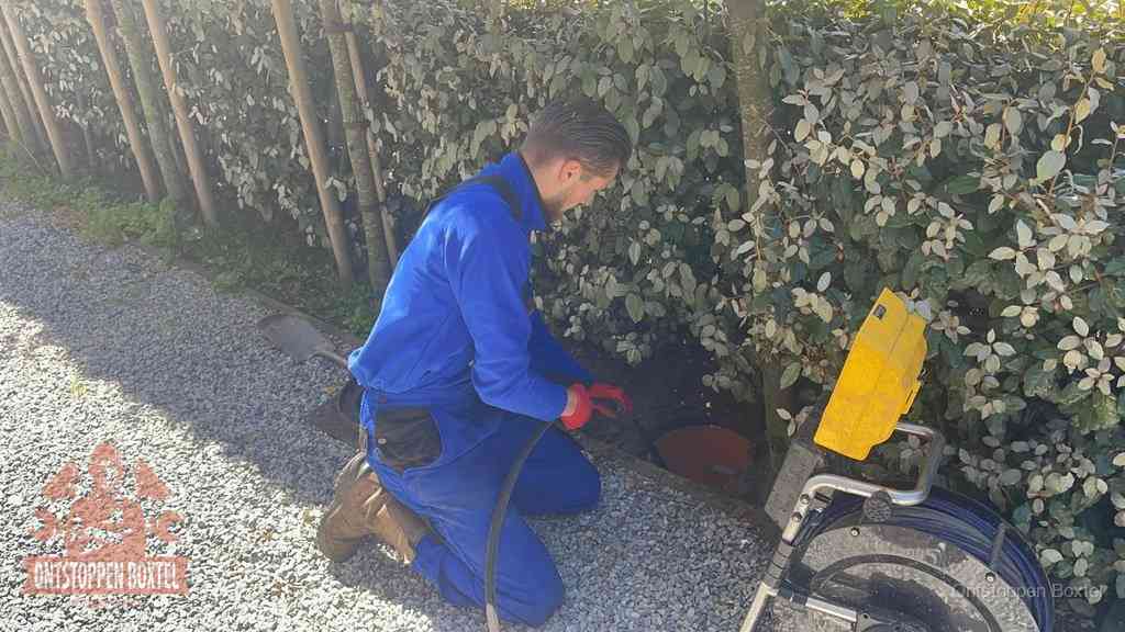 Monteur aan het werk bij een rioolput, de werkwijze voor riool ontstoppen in Boxtel